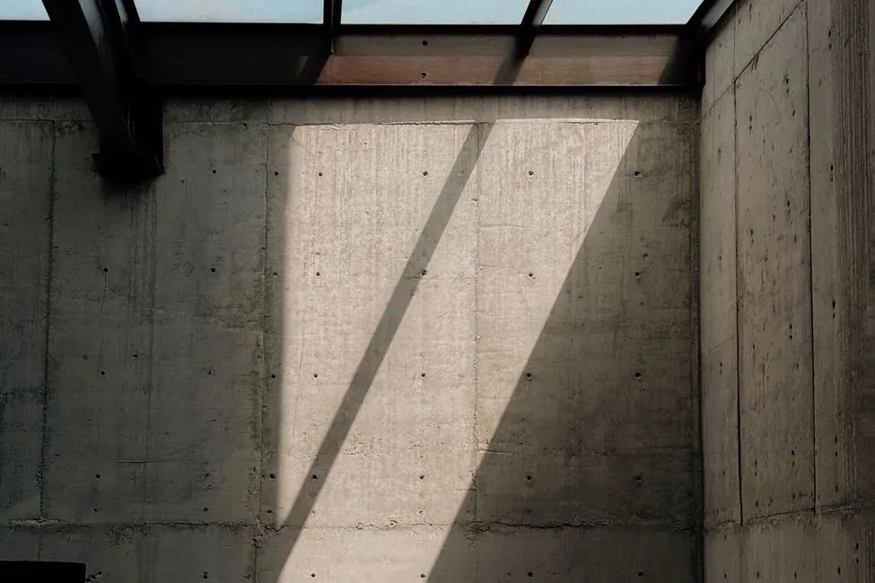 Bare concrete walls under a glass roof, with daylight falling in a single band