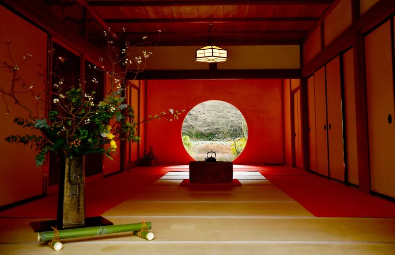 Traditional Japanese room with tatami and a round window onto the garden