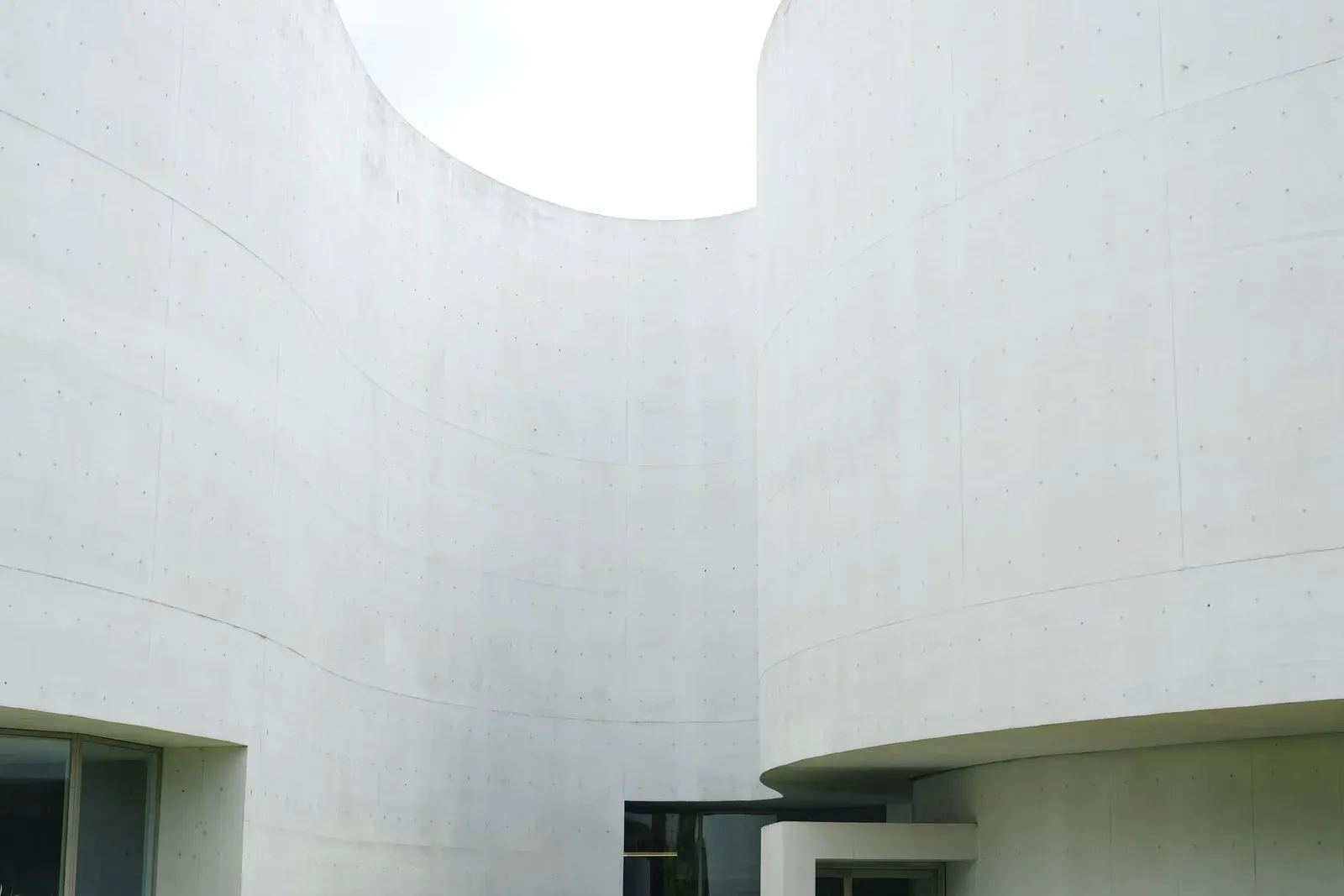 White curving walls of a minimalist museum around a lawn